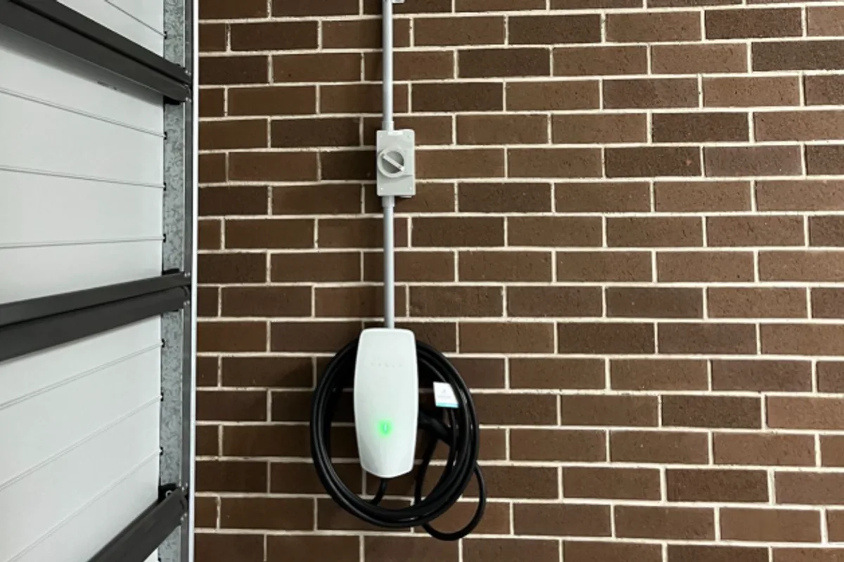 Electric vehicle charger mounted on an exterior wall
