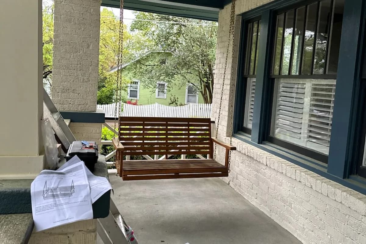 Wooden porch swing installed on a covered porch