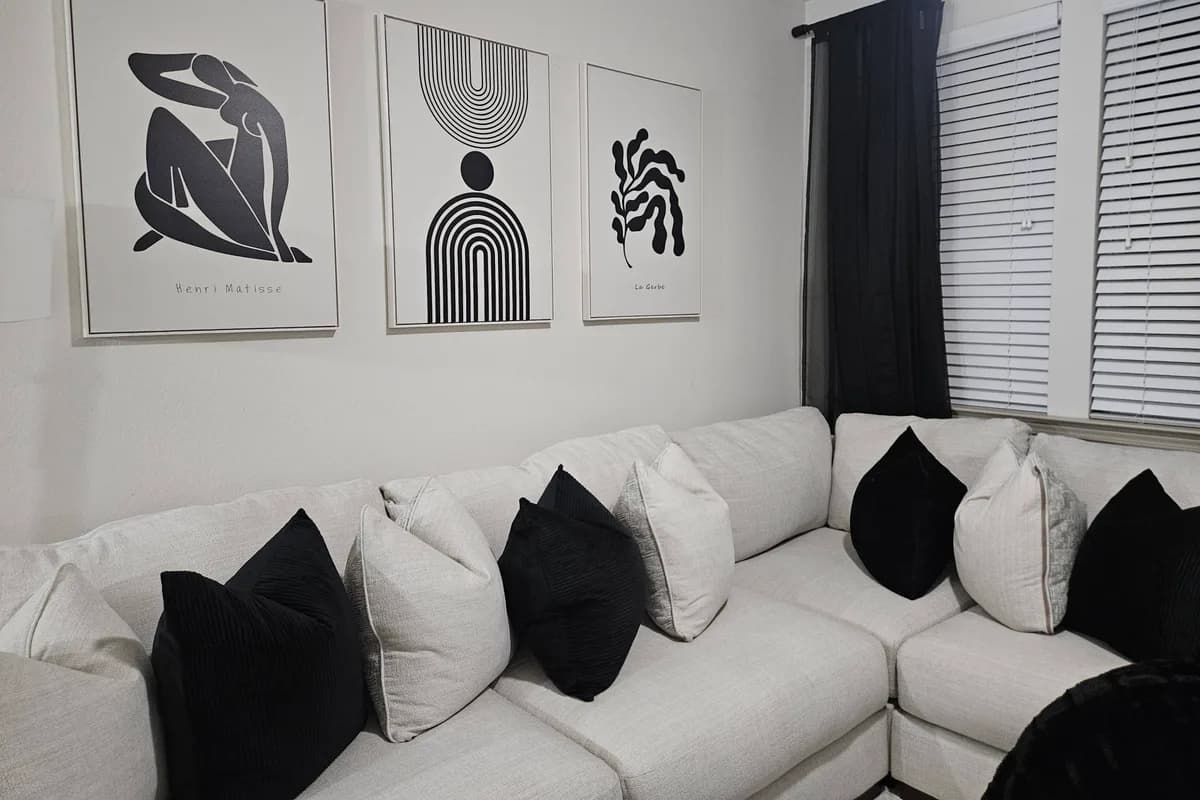 Three framed art pieces mounted above a sofa